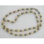 An individually knotted faux pearl necklace in blue and white,