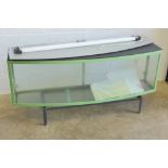 A large glazed metal framed display case, bow fronted, with light over, complete with stand,