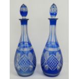 A pair of bohemian decanters with blue overlay glass cut to clear glass, complete with stoppers,