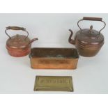 Two copper kettles with lids, the smaller having a turned wooden handle,