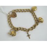 A 9ct gold charm bracelet with heart padlock clasp hallmarked 375, having four 9ct gold charms upon,