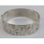 A HM silver bangle having engraved vine and leaf pattern to front, hallmarked Birmingham 1975.