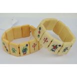 Two vintage Oriental bone panelled bracelets each carved with floral design or characters.