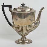 A HM silver coffee pot having gadrooned body and ebonised handle,