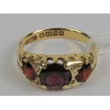 An early 20th century 18ct gold three stone garnet ring,