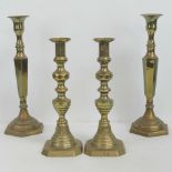 Two pairs of brass single candlesticks, standing 32.5cm and 27.5cm high respectively.