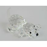 A Swarovski crystal puppy laid on its belly with tail raised, complete with box.