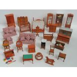 A quantity of wooden dolls house furniture including sofas, bed, crib, wardrobe, display cabinets,