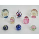 Eight art glass paperweight in blues and pinks.