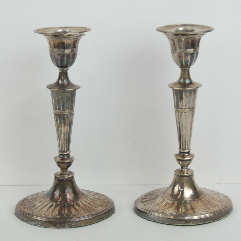 A good pair of HM silver single candlesticks having oval gadrooned bases,