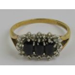 A 9ct gold sapphire and diamond ring having three oval cut sapphires surrounded by a gallery of