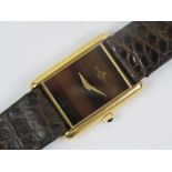 An 18ct gold Baume & Mercier square shaped wristwatch having tigers eye dial, baton hands,
