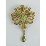 A delightful Edwardian 15ct gold seed pearl and peridot brooch having a central oval peridot