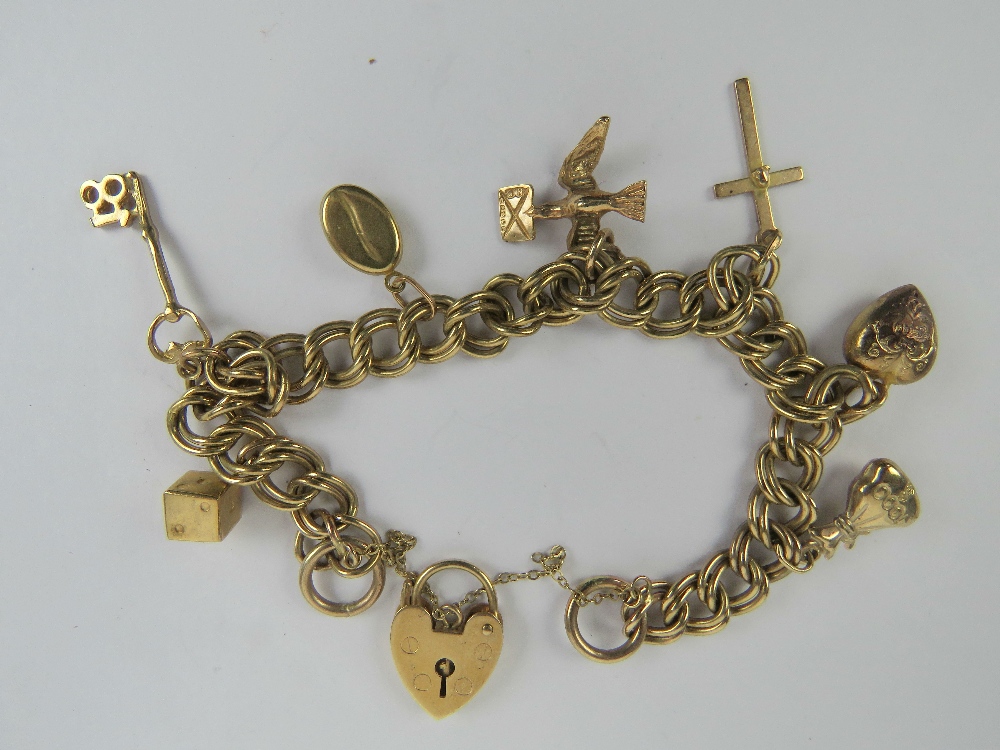 A 9ct gold charm bracelet comprising double curb link chain with heart padlock clasp,