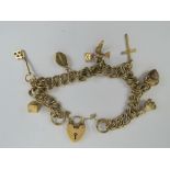 A 9ct gold charm bracelet comprising double curb link chain with heart padlock clasp,