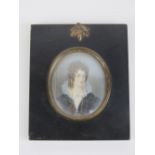 A 19th century portrait miniature on irory of a woman in black with white lace collar wearing a