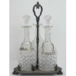 A three bottle tri-form decanter stand with three matching bottles (one stopper deficient) and