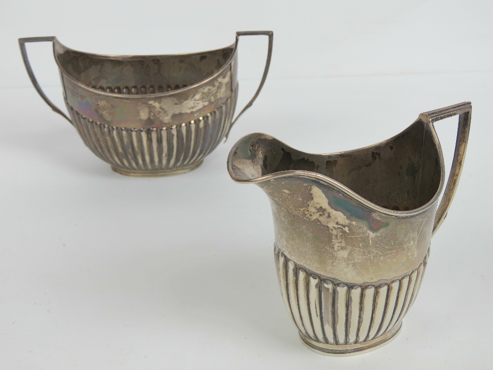 A HM silver jug and sugar bowl set having gadrooned bodies and geometric handles,