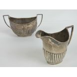 A HM silver jug and sugar bowl set having gadrooned bodies and geometric handles,