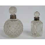 Two cut glass perfume bottles having HM silver collars, 12cm and 14.5cm high respectively.