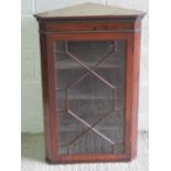 A astral glazed hanging corner cabinet, door opening to reveal shelves within.