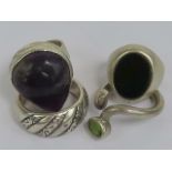 Four white metal rings including a peridot set wrap around ring and a bloodstone signet ring (band