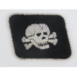 A WWII German SS Totenkopf Regiment officers skull collar patch, in silver thread,