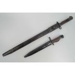 A British Lee Enfield No5 Jungle Carbine bayonet / Sterling SMG bayonet in scabbard.
