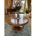 A rosewood circular centre table having circular base and raised over three carved lions paw feet,