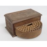 A vintage carved wooden cigarette box having rotating front panel opening to reveal slots for