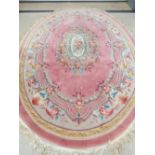 A fine oval pink ground Chinese rug having floral decoration throughout, 312 x 220cm.