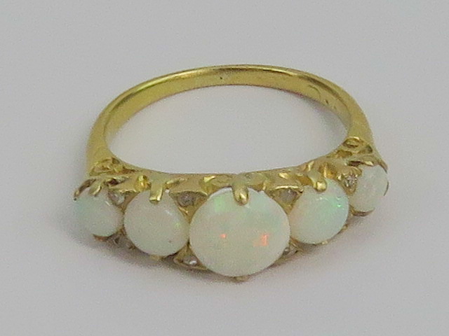 A late Victorian five stone opal cabachon ring having four pairs of diamonds separating each