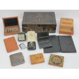 A vintage part carved lidded box containing a quantity of wallets, cases, lighters,