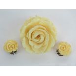 A late Victorian carved ivory brooch in the form of a rose together with a pair of similar clip on