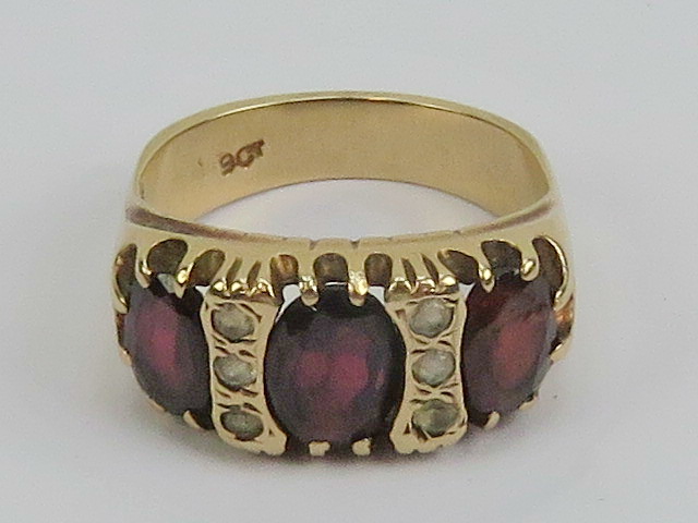 A vintage 9ct gold garnet and spinel ring, the three large graduated garnets,