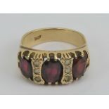 A vintage 9ct gold garnet and spinel ring, the three large graduated garnets,