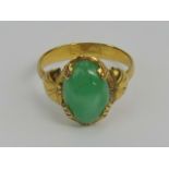 A green jade and yellow metal ring, the jade cabachon measuring approx 11 x 7.8 x 3.