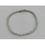 A diamond tennis bracelet each stone in white metal rubover setting, approx total diamond weight 2.