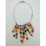 A Baltic and 'Egg Yolk' amber bead necklace having 925 silver clasp.