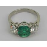 A superb platinum emerald and diamond ring having central green cushion cut Columbian emerald