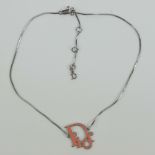 A pink enamel 'Dior' necklace having white metal snake link chain, marked Dior to chain tag.