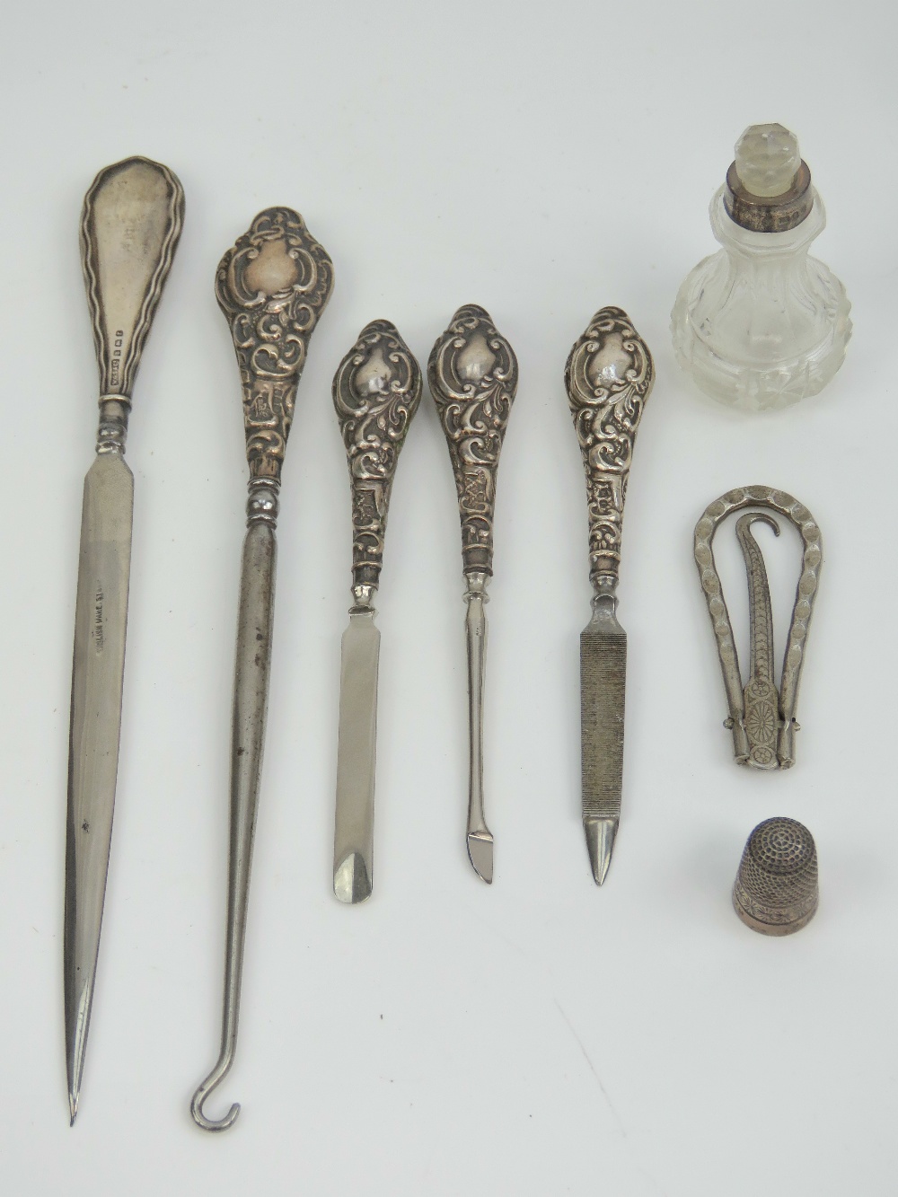 A set of four HM silver handled ladies dressing table items including button hook and nail file,