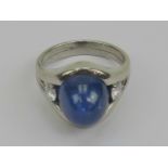 A heavy platinum, sapphire and diamond ring, the large central sapphire cabachon being approx 12ct,