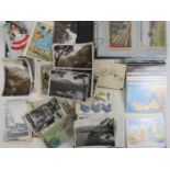 A quantity of assorted vintage early to late 20th Century postcards in two albums and loose,