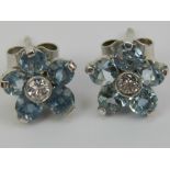 A pair of aquamarine and diamond stud earrings of floral form,