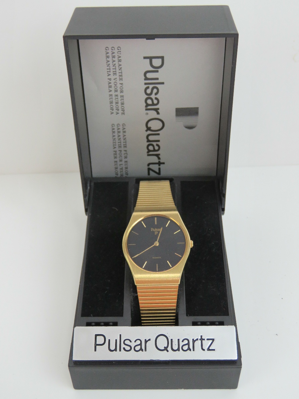 A Pulsar Quartz gold plated wristwatch having circular black ground face,