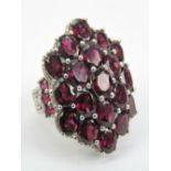 An extremely large HM silver cluster ring comprising 19 oval cut garnets, 925 hallmark, size L-M.