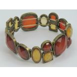 An elasticated hard stone bracelet set with various faceted brown and yellow stone.