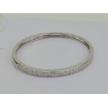 Am 18ct white gold hinged bangle encrusted to the front with three rows of square cut diamonds,