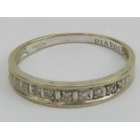 A 9ct white gold and diamond ring having eleven round cut claw set diamonds, hallmarked 375, size L,